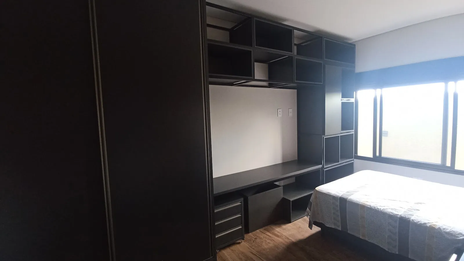 Dormitório com home office e estante planejados
