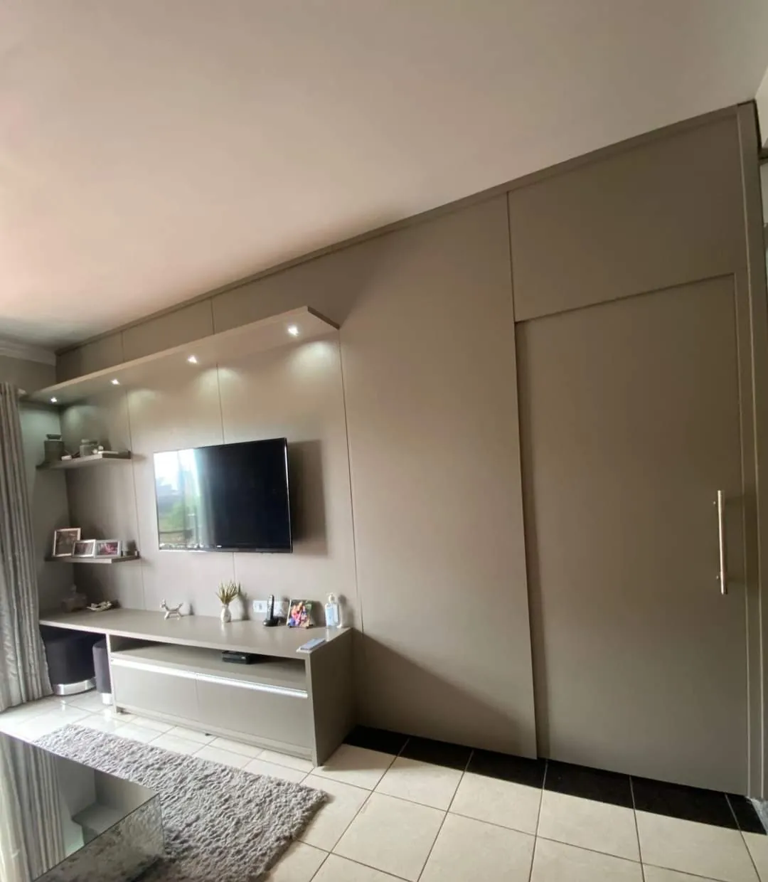 Dormitório com painel de TV e guarda-roupa de correr